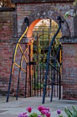 MORTON HALL GARDENS, WORCESTERSHIRE: ORNAMENTAL METAL GATE AT ENTRANCE TO KITCHEN GARDEN, SUNSET