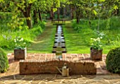 COTON MANOR GARDEN, NORTHAMPTONSHIRE: SPRING, MAY, RILL GARDEN, WATER STAIRCASE, CONTAINERS OF TULIPS, TULIPA SPRING GREEN, GRASS, MEADOW, WATER FEATURE, WOODEN BENCH, SEAT