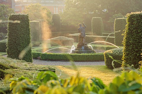 EN_HOUSE_SOMERSET_EARLY_MORNING_MIST_ON_FORMAL_PARTERRE_TERRACE_WATER_FEATURE_FOUNTAIN_TOPIARY_FOCAL