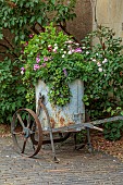 ADMINGTON HALL, WARWICKSHIRE: METAL WHEELED CONTAINER FILLED WITH GERANIUMS, PELARGONIUMS