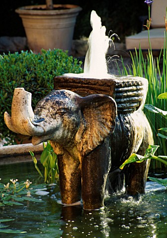 STONE_ELEPHANT_FOUNTAIN_STANDS_IN_CIRCULAR_POOL_IN_THE_PEBBLED_COURTYARDLA_CASELLA_FRANCEDESIGNCLAUS