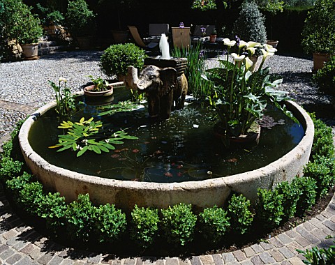 A_STONE_ELEPHANT_FOUNTAIN_IN_A_CIRCULAR_POOL_IN_THE_PEBBLED_COURTYARD_LA_CASELLA__FRANCE_DESIGNER_CL