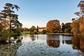 SPETCHLEY PARK GARDENS, WORCESTERSHIRE: VIEW ACROSS LAKE, AUTUMN, OCTOBER, EVENING LIGHT, HOUSE, TREES