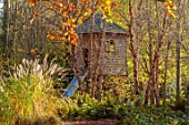THE OLD RECTORY, QUINTON, NORTHAMPTONSHIRE: DESIGNER ANOUSHKA FEILER: GRASSES, AUTUMN, FALL, WOODEN TREE HOUSE, SLIDE, WOODLAND, FERNS, BIRCHES