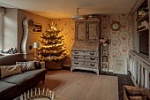 PEAR TREE COTTAGE, OXFORDSHIRE: SITTING ROOM, CHRISTMAS TREE, FRENCH BUREAU, SWEDISH MORA CLOCK, CUSHIONS, DRUM COFFEE TABLE, CANDLE RING