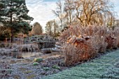 THE OLD RECTORY, QUINTON, NORTHAMPTONSHIRE: DESIGNER ANOUSHKA FEILER: GRASSES, FROST, WINTER, GARDEN, ENGLISH, COUNTRY, JANUARY, HYDRANGEAS, POND, POOL, WATER, WOODEN BRIDGE