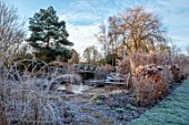 THE OLD RECTORY, QUINTON, NORTHAMPTONSHIRE: DESIGNER ANOUSHKA FEILER: GRASSES, FROST, WINTER, GARDEN, ENGLISH, COUNTRY, JANUARY, HYDRANGEAS, POND, POOL, WATER, WOODEN BRIDGE