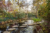 MORTON HALL GARDENS, WORCESTERSHIRE: POOL, WATER, STEPPING STONES, REFLECTIONS, CHERRIES, PRUNUS INCISA YAMADEI, UPPER POND, STROLL GARDEN, JAPANESE, MARCH, SPRING, SCILLA SIBERICA