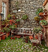 PATTHANA GARDEN, IRELAND: THE POTTING SHED, BEGONIAS, COBBLED FLOOR, BENCH, SEAT, STONE WALLS