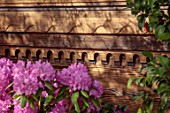 CHELSEA 2022: A SWISS SANCTUARY BY LILLY GOMM: PINK RHODODENDRON AND ORNATE SWISS CHALET FENCE, FENCING