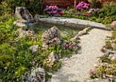 CHELSEA 2022: A SWISS SANCTUARY BY LILLY GOMM: METAL SEAT, BENCH, RHODODENDRONS, GRAVEL PATHS, ROCKS, WATERFALL, POOL, POND