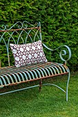 ASHBROOK HOUSE, NORTHAMPTONSHIRE: METAL CHAIR, LAWN, CUSHIONS, BENCH, YEW HEDGES, HEDGING