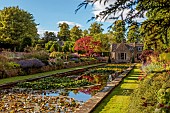 THE SUMMERHOUSE, OXFORDSHIRE: JULY, SUMMER, VIEW ALONG CANAL, POND, POOL, WATER, GARDEN TO HOUSE, BORDERS, YEW PYRAMIDS, MAPLES, TREES, WATERLILIES
