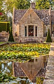 THE SUMMERHOUSE, OXFORDSHIRE: JULY, SUMMER, VIEW ALONG CANAL, POND, POOL, WATER, GARDEN TO HOUSE, YEW PYRAMIDS,TREES, WATERLILIES, REFLECTED, REFLECTIONS