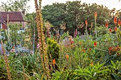 HIGHLANDS, SUSSEX: SUMMER, BORDERS, RED HOT POKERS, KNIPHOFIA, TERRACOTTA CONTAINER, HOUSE, STIPA GIGANTEA, LOBELIA TUPA, CLEMATIS, LAVATERA, VERBASCUM