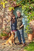 THE LAUNDRY GARDEN, DENBIGH, WALES: JENNY AND TOM WILLIAMS WITH THEIR DOG AT THE WALLED GARDEN ENTRANCE GATE