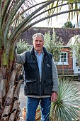 THE PALM CENTRE, LONDON: MARCH, OWNER MARTIN GIBBONS BESIDE TWO SPECIMENS OF BUTIA ODORATA