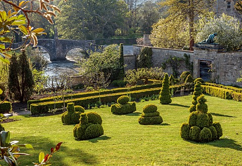 IFORD_MANOR_WILTSHIRE_APRIL_VIEW_FROM_THE_KITCHENL_VEGETABLE_GARDEN_LAWN_TOPIARY_BRIDGE_RIVER_AVON_W