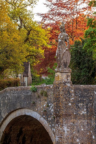 IFORD_MANOR_WILTSHIRE_MAY_SPRING_VIEW_ACROSS_BRIDGE_OVER_RIBVER_FROME_WITH_STATUE_OF_BRITANNIA