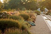 GRANTLEY HALL, YORKSHIRE: GRAVEL GARDEN, PATINATED STEEL AND COLOURED STAINLESS STEEL GLAZED CUPOLA SEAT AT END OF RILL, BORDERS, GRASSES, SHRUBS, PERENNIALS, SEPTEMBER