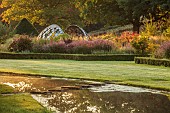 GRANTLEY HALL, YORKSHIRE: LIGHTING, DAWN, BOX EDGED BEDS, WATER, POOL, STEPPING STONES, PATINATED STEEL AND COLOURED STAINLESS STEEL GLAZED CUPOLA SEAT, BORDERS, GRASSES, SEPTEMBER