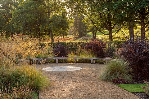 GRANTLEY_HALL_YORKSHIRE_GRAVEL_GARDEN_CURVED_WOODEN_SEAT_BENCH_A_PLACE_TO_SIT_STIPA_GIGANTEA_WOODS_T