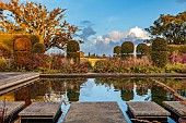 BROUGHTON GRANGE GARDENS, OXFORDSHIRE: FALL, AUTUMN, OCTOBER, WALLED GARDEN, STEPPING STONES, RECTANGULAR POND, POOL, WATER, CLIPPED BEECH, BORROWED LANDSCAPE