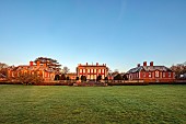 COTTESBROOKE HALL AND GARDENS, NORTHAMPTONSHIRE: HALL FROM THE SOUTH LAWN, MARCH, SPRING, SUNRISE