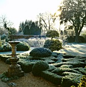 THE KNOT GARDEN IN FROST  WITH SUNDIAL &  CLIPPED BALLS OF GOLDEN KING HOLLY  BARNSLEY HOUSE  GLOUCESTERSHIRE