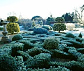 FROST COVERED KNOT GARDEN  WITH SUNDIAL &  CLIPPED BALLS OF GOLDEN KING HOLLY.  BARNSLEY HOUSE  GLOUCESTERSHIRE
