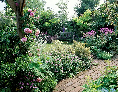 SECLUDED_SEAT_AND_BRICK_PATHWAY_BESIDE_PERGOLA_WITH_ROSE_CONSTANCE_SPRYIN_PINK_BORDER_DESIGNER_ROGER