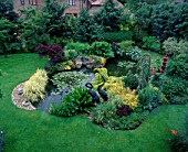 JAPANESE STYLE LILY POND AND WATERFALL SURROUNDED BY EVER- GREENS & CONIFERS. HAM MANOR. DESIGNER: JULIAN TREYER-EVANS