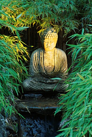 STONE_BUDDHA_LIT_BY_GARDEN__SECURITY_LIGHTING_IN_THE_NATURAL__ORIENTAL_WATER_GARDENS__HAMPTON_COURT_