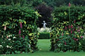 VIEW THROUGH GAP IN PINK BORDER TO WHITE GARDEN AND STATUE OF CUPID. CHENIES MANOR  BUCKINGHAMSHIRE.