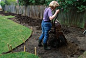 APPLICATION OF TOP-SOIL TO NEWLY STAKED OUT FLOWER BEDS