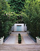 A PEACEFUL PLACE IN CHARLES WORTHINGTONS MINIMALIST GARDEN: GRAVEL PARTERRE WITH BOX SQUARES AT CENTRE  LEADING TO SIMPLE WATER FEATURE. DESIGNER:STEPHEN WOODHAMS