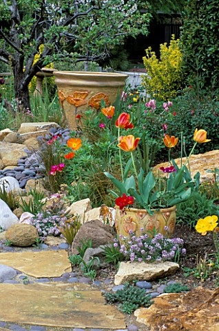 DRY_CREEK_BED_WITH_CERAMIC_POTS_BY_KEEYLA_MEADOWS_PLANTED_WITH_ORANGE_TULIPS