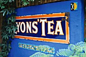 DECORATIVE FEATURE: A LYONS TEA SIGN  A MOSAIC AND A SMALL PAINTED MEXICAN TILE ON AN ULTRAMARINE BLUE WALL. DESIGN: ANDREW & KARLA NEWELL