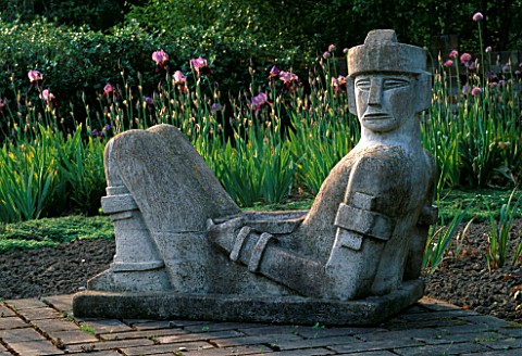 CHAK_MOOL_RAIN_GOD_SCULPTURE_BY_HELEN_SINCLAIR_WITH_IRIS_IN_THE_BACKGROUNDARROW_COTTAGE__HEREFORDSHI