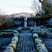 EARLY MORNING FROSTY VIEW DOWN A BOX EDGED BRICK PATH TO A STONE URN WITH THE HILLS BEYOND.  ARROW COTTAGE  HEREFORDSHIRE