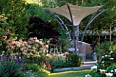 MODERN STEEL AND CANVAS CANOPY WHICH ACTS AS A PARASOL  RAINCATCHER AND SOLAR PANEL IN MODERN GARDEN. TELEGRAPH REFLECTIVE GARDEN  CHELSEA 99.