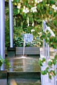WATER FEATURE: STEPPED CANAL WITH CLASSICAL TRITON MASK WATER SPOUT SURROUNDED BY ARCHITECTURAL FORMS IN MODERN GARDEN. TELEGRAPH REFLECTIVE GARDEN  CHELSEA 99.