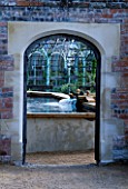 WATER FEATURE: ARCHWAY THROUGH TO STEW POND AND HERB GARDEN. THE ABBEY HOUSE  WILTSHIRE.