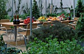 A PLACE TO SIT: WICKER SEATS WITH WINE   APRICOTS  TOMATOES  LEMONS AND PEAS ON THE TABLE. THE CHEFS ROOF GARDEN  CHELSEA 1999.