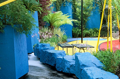 VIVID_BLUE_WALLS_AND_ROCKS_WITH_SEATING_AND_CYCAS_REVOLUTA__HOSTA__ACER_JAPONICUM_AND_GUNNERA_MANICA