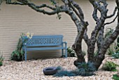 A PLACE TO SIT: LIGHT BLUE PAINTED BENCH WITH LILIUM REGALE  APPLE TREE & MAD EGG SCULPTURE BY AVANT GARDENER IN CLARE MATTHEWS GRAVEL GARDEN  READING.