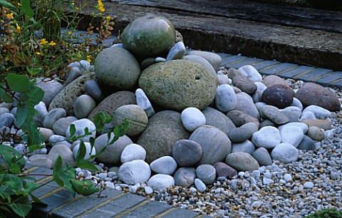 WATER_FEATURE_A_PILE_OF_SEA_WORN_PEBBLES_AND_GRAVEL_CREATE_A_SMALL_FOUNTAIN_ROBIN_GREEN__RALPH_CADES