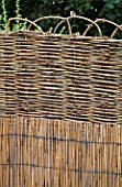 SPLIT BAMBOO AND WOVEN WILLOW PANEL CREATES STRONG VERTICAL AND HORIZONTAL LINES . ROBIN GREEN AND RALPH CADES SEASIDE STYLE GARDEN  LONDON.