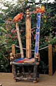 A PLACE TO SIT: AN ASTROLOGICAL THRONE MADE FROM RECYCLED WOOD & ROUGHLY PAINTED. AT THE TOP IS A CARVED CRAB & LION. ROBIN GREEN AND RALPH CADES SEASIDE STYLE GARDEN  LONDON