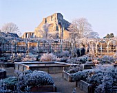 FROZEN POND CREATES A FOCAL POINT FOR THE HERB GARDEN WITH FROSTED WIGWAMS  THE CIRCULAR ARCADED WALK & RUINED ABBEY IN THE BACKGROUND. THE ABBEY HOUSE  WILTSHIRE. (SAME AS 20132)